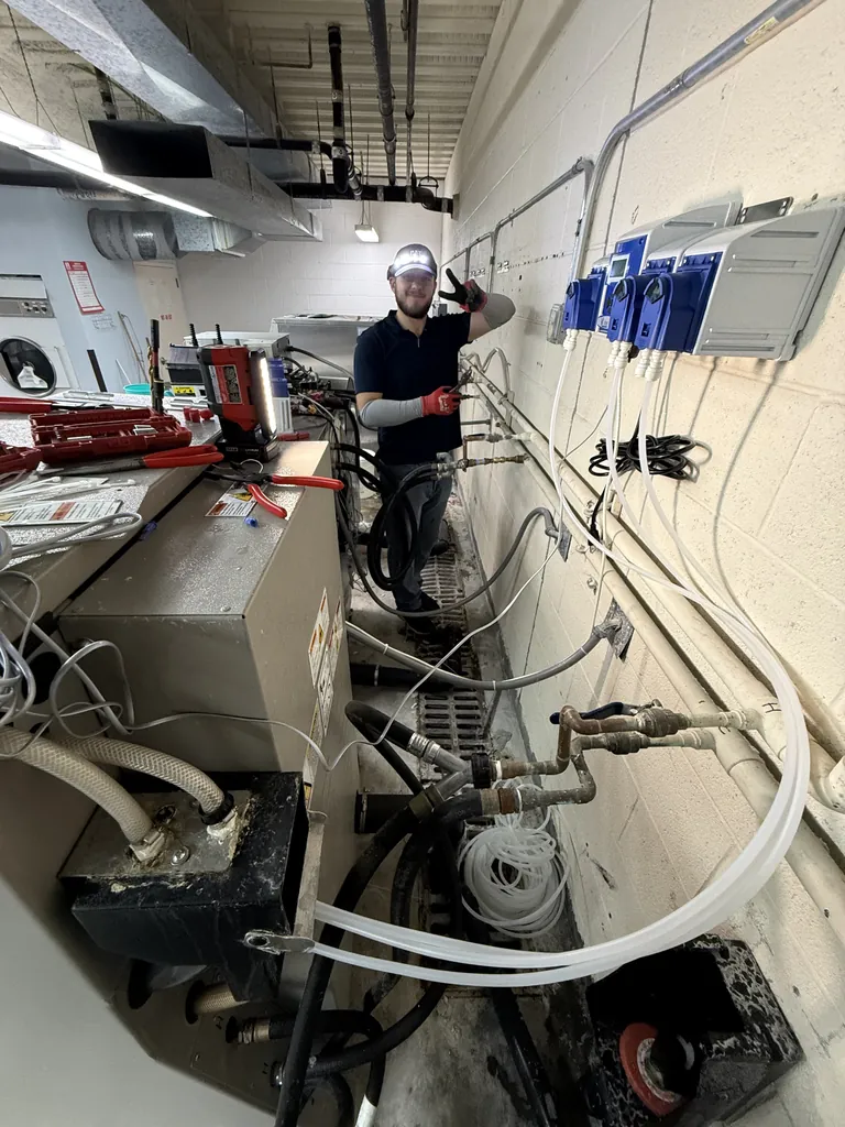 Red Rock Appliance Services technician finishing a commercial laundry dispenser installation in Las Vegas