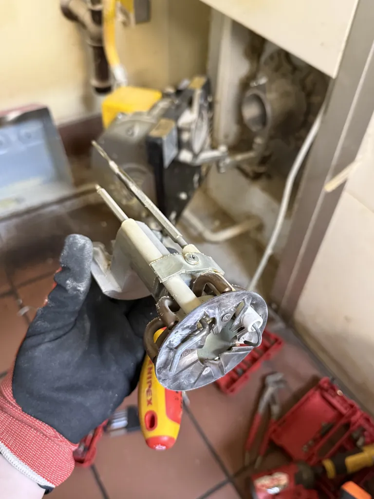 Polin oven burner head with flame sensor, igniter electrode and gas orifice removed for cleaning