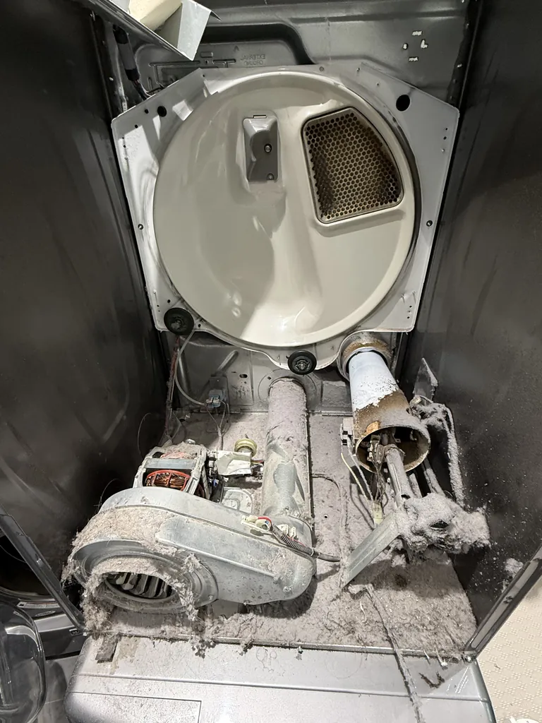 Thick lint buildup around the blower, motor and heating element inside a stacked dryer in Henderson